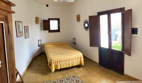 a room with a bed and a window in it at Dammusino: mini-appartamento in Pantelleria