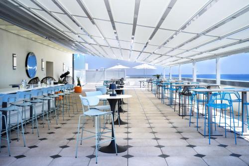 a restaurant with tables and chairs and the ocean at Courtyard By Marriott Titusville Kennedy Space Center in Titusville