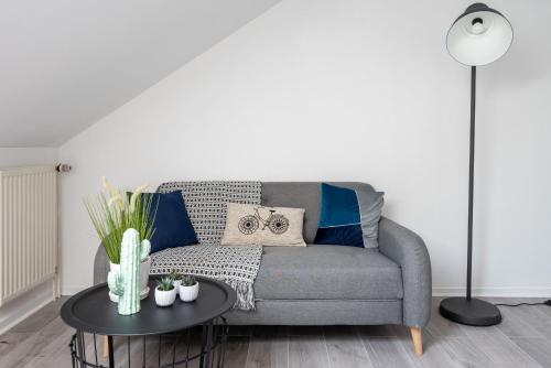 un salon avec un canapé gris et une table dans l'établissement L’Appartement du Loup Gorge de loup - Lyon, à Lyon
