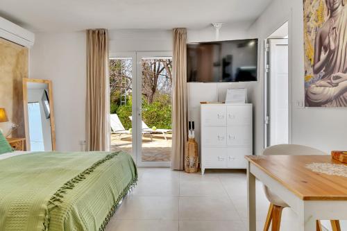 een slaapkamer met een bed en een tafel en een eetkamer bij Casa La Naranja Boutique Hotel B&B LaCasita in Pedreguer