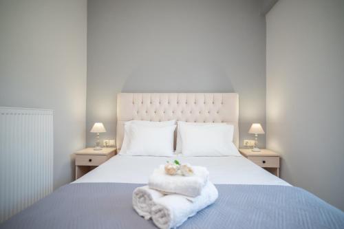 een slaapkamer met een bed met handdoeken en 2 lampen bij Famozo Hill Private Villa in Káto Yerakaríon