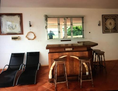 un bar en una habitación con sillas y una ventana en La villa chez Ingrid, en Antsiakambony