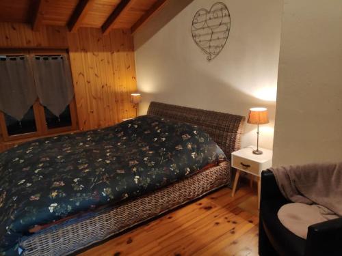 une chambre avec un lit et une table avec une lampe dans l'établissement Maison Cosy et Conviviale, Le B7, à Besset