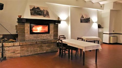 a dining room with a fireplace and a table and chairs at camere in Villa Luzi in Treia