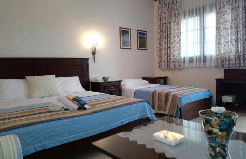 um quarto de hotel com duas camas e uma mesa em Philoxenia Hotel em Paranesti