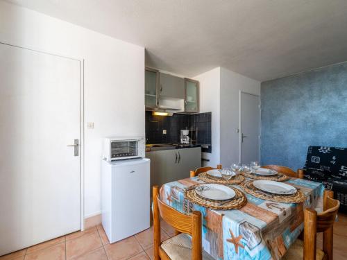 une cuisine et une salle à manger avec une table et des chaises dans l'établissement Apartment Les Balcons de la Méditerranée-37 by Interhome, à Narbonne-Plage