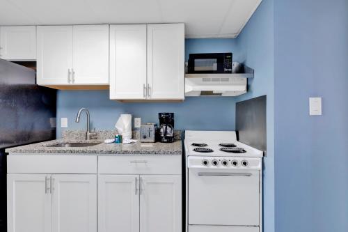 a kitchen with white cabinets and a white stove top oven at Hosteeva Boardwalk Ocean-front Condo in Myrtle Beach