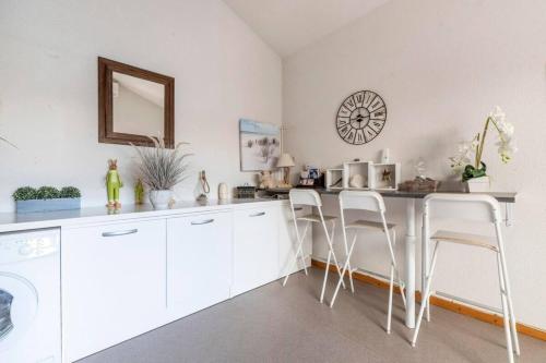 a kitchen with white cabinets and a counter with stools at Between sea and Garrigues! in Vic-la-Gardiole