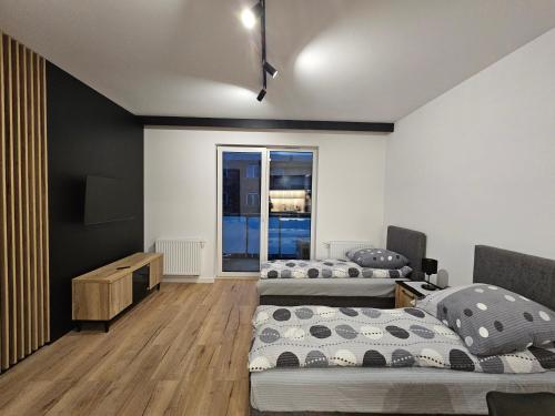 ein Schlafzimmer mit zwei Betten und einem Fenster in der Unterkunft Apart Family Lębork in Lębork