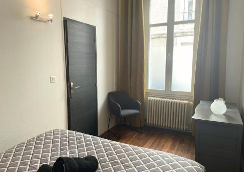 - une chambre avec un lit, une chaise et une fenêtre dans l'établissement Le Thibaudeau, à Poitiers