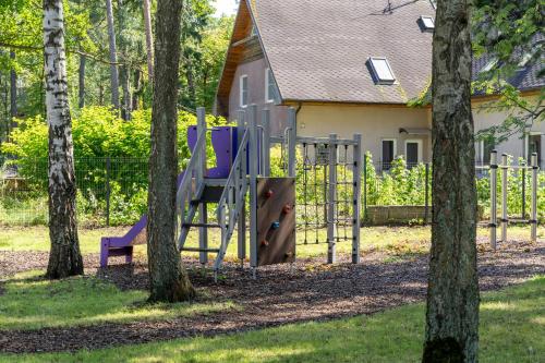 a playground in front of a house with trees at Apartments with private parking & terrace in Jūrmala