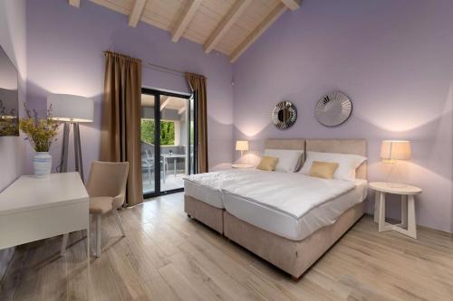 sypialnia z dużym białym łóżkiem i biurkiem w obiekcie Villa Tre Olive by Istrialux w mieście Grandići