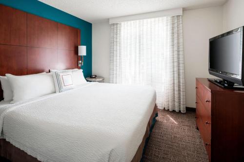 a bedroom with a large bed and a flat screen tv at Residence Inn San Ramon in San Ramon