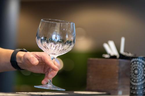 a hand holding a wine glass on a table at Solna Park & Hotel in Solna