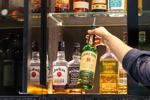 a person is holding up a bottle of alcohol at Solna Park & Hotel in Solna