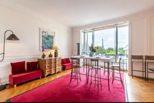 a living room with a red couch and a table at 4 bedroom Luxury Eiffel Tower Apartment in Paris