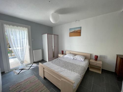 une chambre avec un lit et une grande fenêtre dans l'établissement Maison au soleil, à Banyuls-sur-Mer