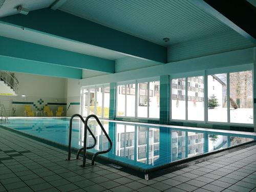 a swimming pool in a building with a swimming pool at Schloss Grubhof Appartement in Sankt Martin bei Lofer