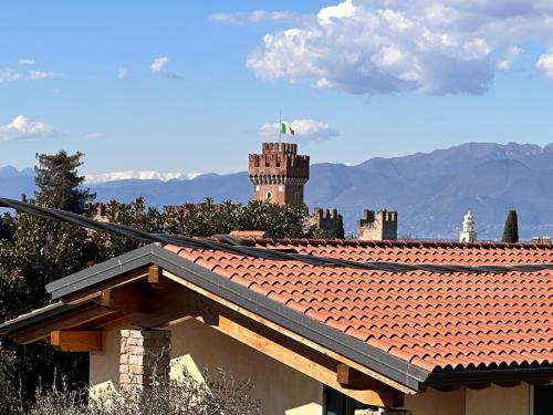a building with a red tile roof with a tower at APPARTAMENTO LIDA in Lazise