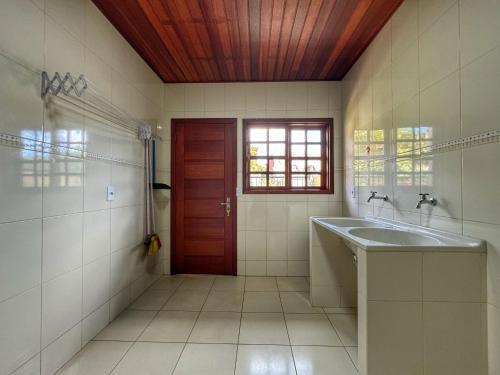 baño con lavabo y puerta roja en Casa Luar, en Monte Verde