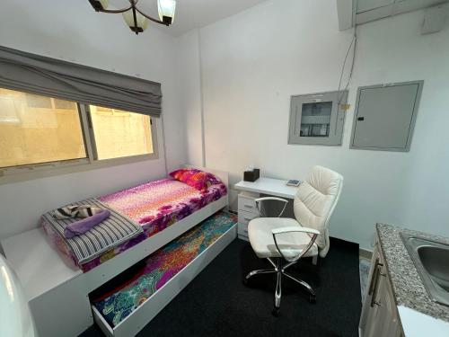 a bedroom with a bed and a desk and a chair at The Regal Residency Studio, 1 Minute Walking Distance from Gold Souk in Dubai