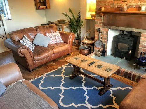 a living room with a couch and a fireplace at Lavender Row Stedham in Midhurst