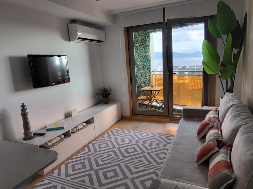 a living room with a couch and a tv at Apartamento Sanxenxo Carles Deluxe Ocean View in Sanxenxo