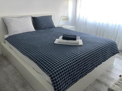 1 dormitorio con 1 cama con una manta azul y blanca a cuadros en A cozy and modern apartment Krasno selo, en Sofía