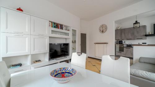 uma sala de estar branca com uma mesa e cadeiras em Italianway - Betti 46 em Rapallo