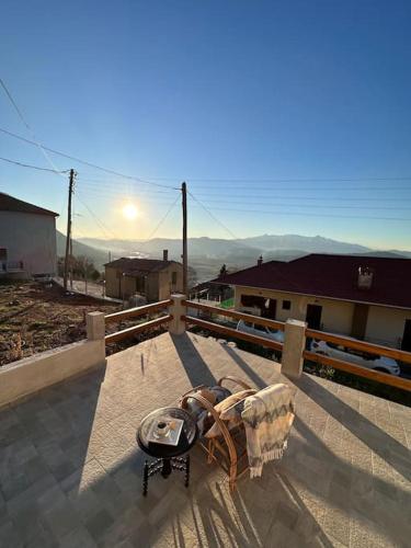 a chair sitting on a porch with the sun in the background at Casa Di Munti in Konitsa