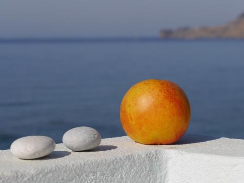 an apple and three eggs on a table at Skinos Apartments in Plakias