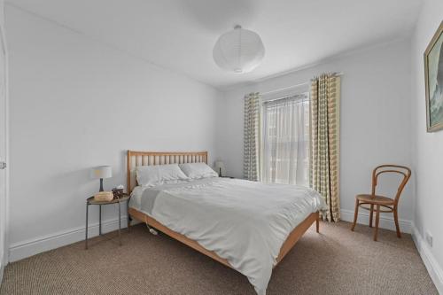 a bedroom with a bed and a table and a chair at St John's Corner Cottage, Bury St. Edmunds in Bury Saint Edmunds