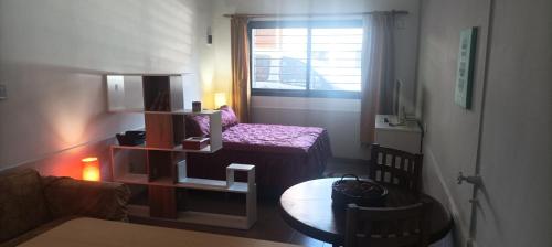 um pequeno quarto com uma cama e uma mesa em Mono Ambiente C em General José de San Martín