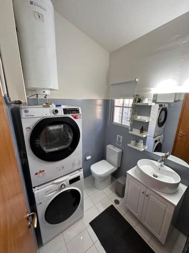 a small bathroom with a washing machine and a sink at Casa Di Munti in Konitsa