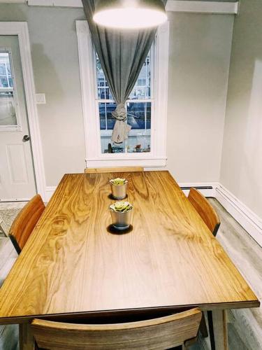 a wooden table with a vase on top of it at Spin & Sip - Dog-Friendly Vinyl Vibes Downtown in Fredericton