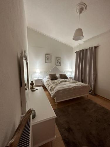 a white bedroom with two beds and a mirror at Casa Di Munti in Konitsa