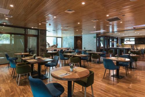 a restaurant with wooden floors and tables and chairs at Courtyard by Marriott Puerto Montt in Puerto Montt