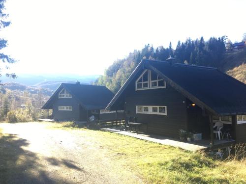 dos casas en una colina con árboles en el fondo en Kvamskogen & Hardanger Holliday homes en Norheimsund