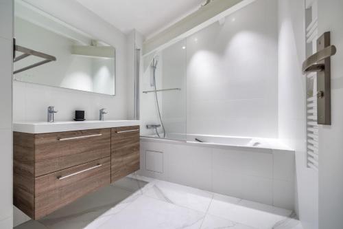 a white bathroom with a tub and a sink at Chaleureux appartement6personnes in Asnières-sur-Seine