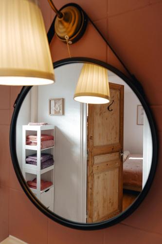 a mirror in a room with a door and two lamps at Hôtel l'Abbaye in Saint-Cyprien