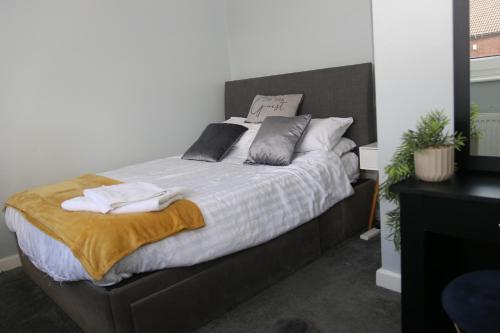 a bedroom with a large bed with towels on it at Comfy 2-Bedroom House in Parkgate - Ideal for Contractors/Business Travellers in Rotherham