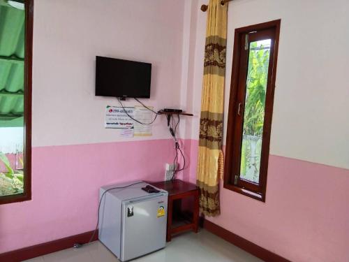 a room with a small refrigerator and a window at Ruen Nam Khoa Resort -Klongthom Krabi in Khlong Thom