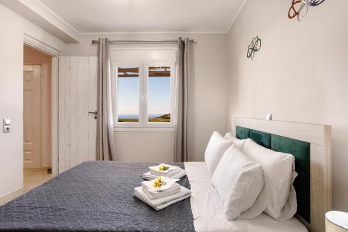 a bedroom with a bed with two towels on it at Iliovasilema Holiday House in Volimes