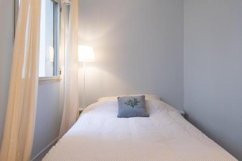Habitación pequeña con cama con almohada. en Quiet radiant studio overlooking the garden, en París