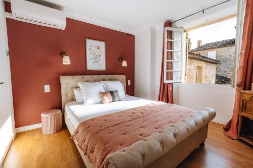 a bedroom with a large bed and a window at Hôtel l'Abbaye in Saint-Cyprien