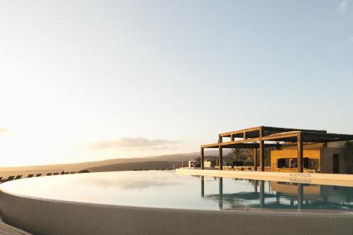 un rendimiento de una piscina con un edificio en Salobre Hotel Resort & Serenity, en Salobre