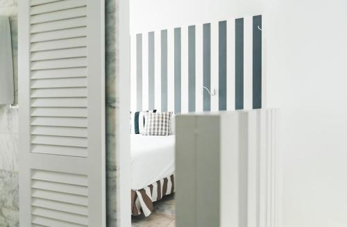 - une chambre avec un lit blanc et un mur rayé dans l'établissement Marina Bayview Gran Canaria - Adults Only, à Puerto Rico