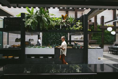 a man standing in front of a counter in a restaurant at Salobre Hotel Resort & Serenity in Salobre