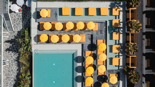 an overhead view of a swimming pool with yellow chairs at Buendía Corralejo Nohotel in Corralejo