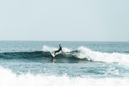 a person riding a wave on a surfboard in the ocean at Buendía Corralejo Nohotel in Corralejo